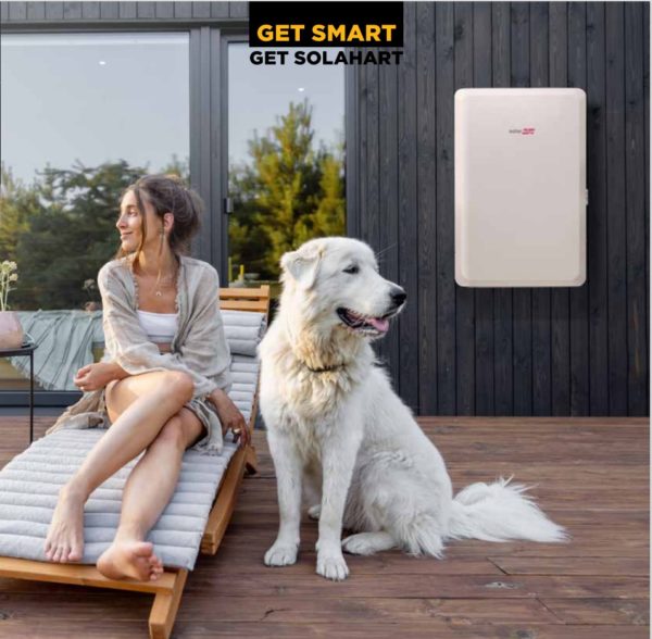 SolarEdge battery installed on outside of house with lady and dog in foreground